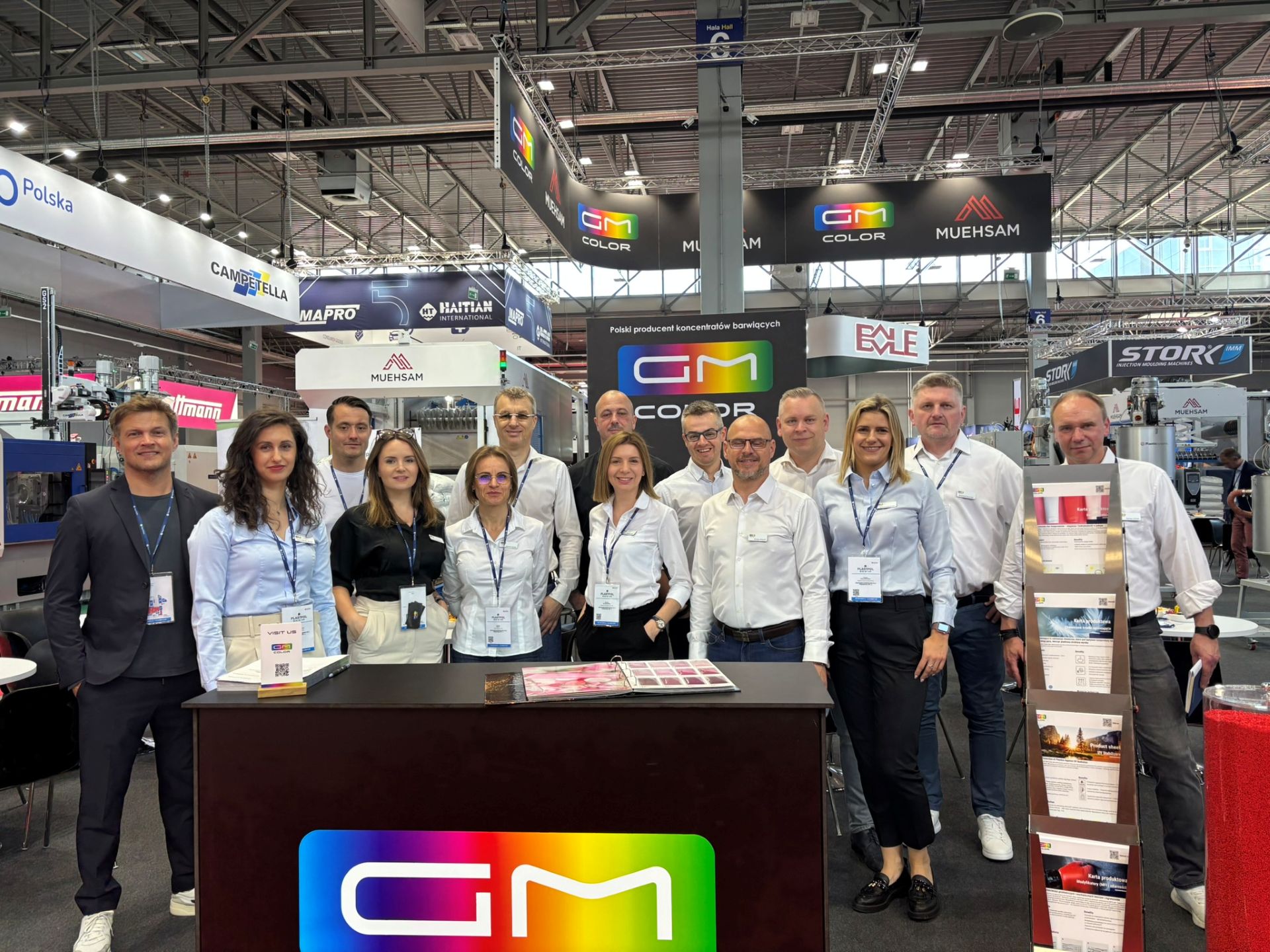 pracownicy firmy stojący w rzędzie na stoisku firmowym GM Color na targach plastpol 2025